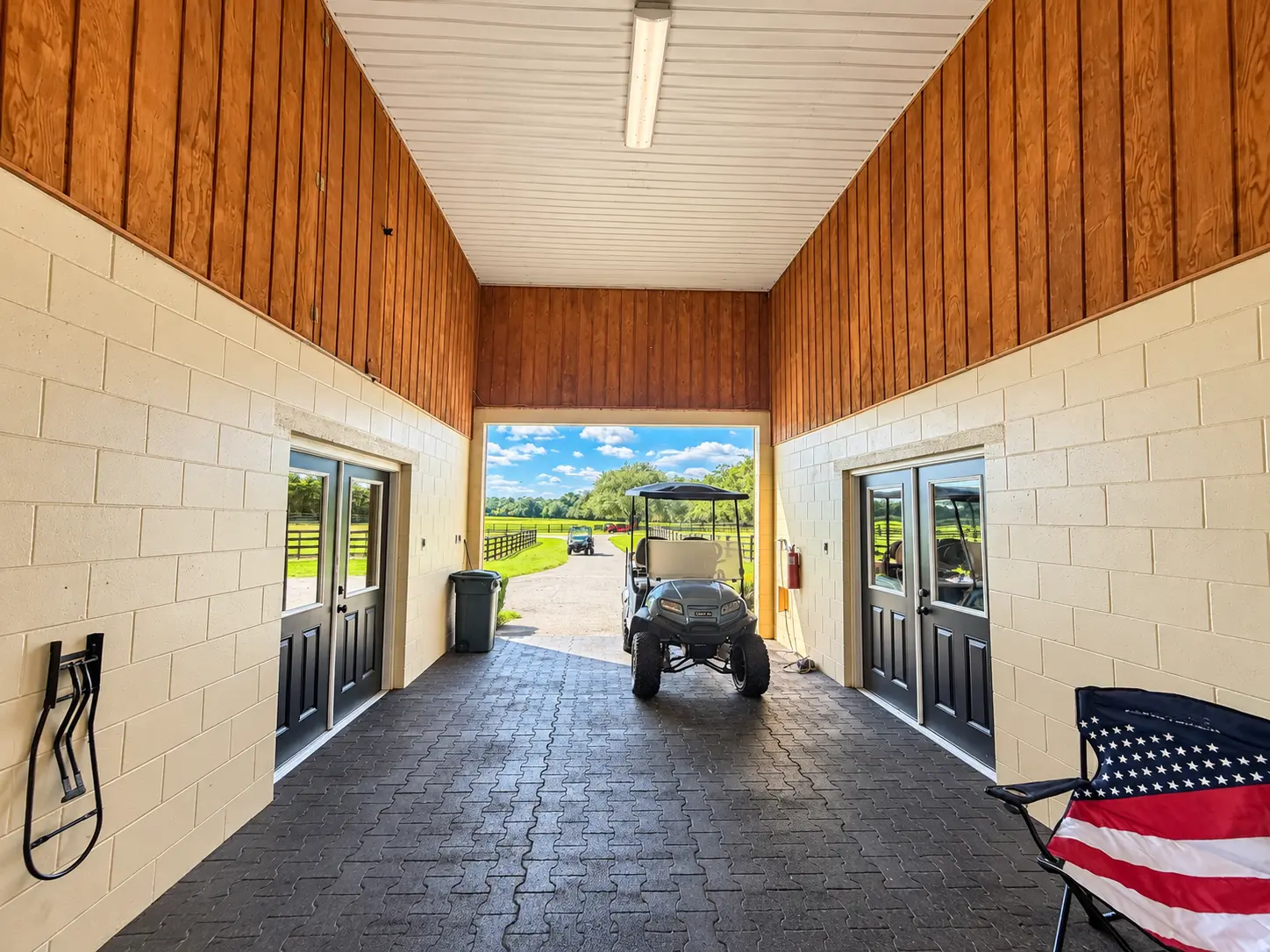 The breezeway looking out past open doors to the pastures and driveway